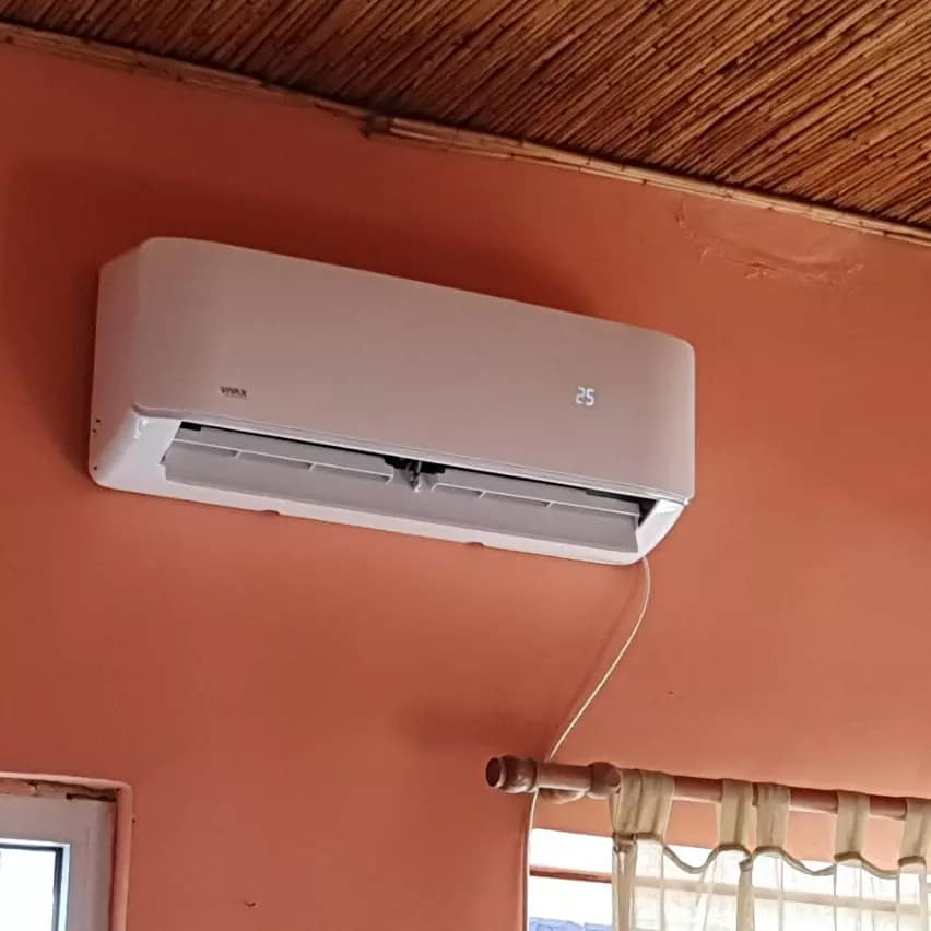 Klima uređaj na narandžastom zidu